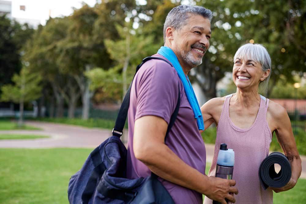mature couple smiling after fitness class in the park
